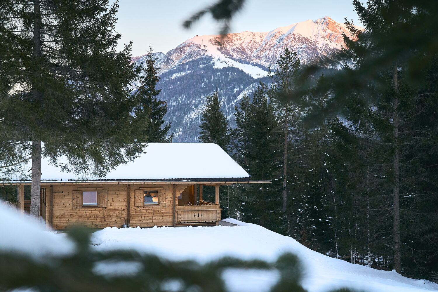 mei chalet - DAS BARBARA Das verschneite Chalet am Waldrand, dahinter die Seefelder Berge im Alpenglühen